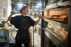 Olha Hrynchuk, 28, owner of a bakery in Kyiv, bakes bread early morning running on a generator during a blackout caused by Russia's regular air attacks on the country's energy system, Jan. 30, 2026.