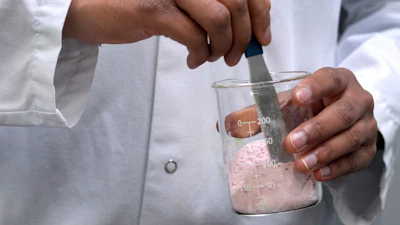 Applications scientist Anuj Bag mixes coloring with flour at Sensient Technologies Corp., a color additive manufacturing company, April 2, 2025, St. Louis.