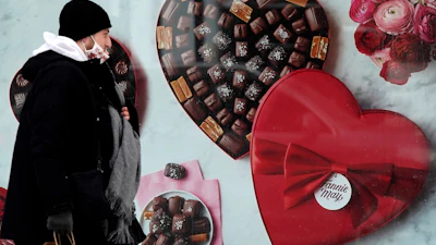 A man passes a Fannie May chocolate shop in Chicago, Feb. 14, 2021.