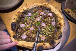 A customer cuts a Roman-era pizza in Budapest, Hungary, Feb. 11, 2026.