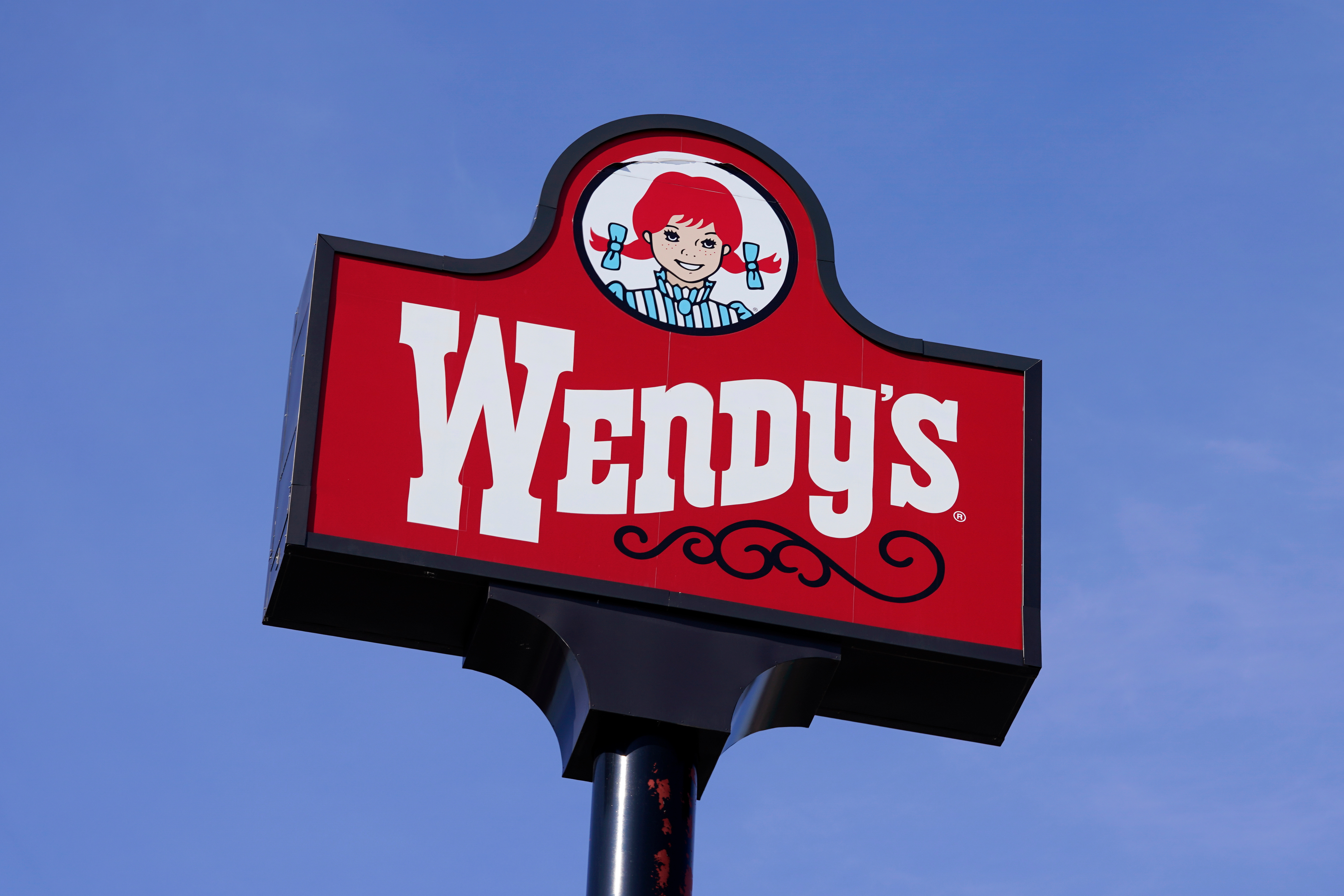 A sign stands over a Wendy's restaurant, Feb. 25, 2021, Des Moines, Iowa.