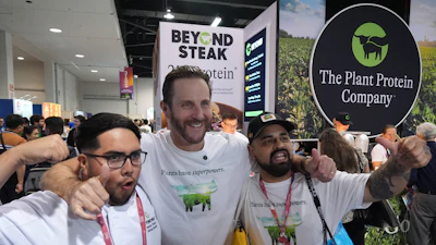 Beyond CEO Ethan Brown, center, with Beyond Meat kitchen assistant Hector Torres, left, and Antonio Partida Sr., kitchen prep, at the Natural Products Expo West, Anaheim, Calif., March 5, 2026.