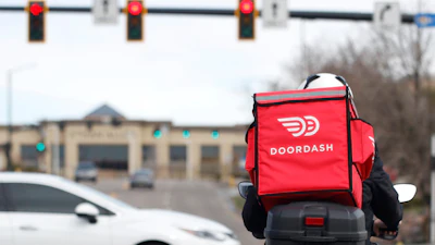 A food delivery motorcycle rider at a traffic light in Lone Tree, Colo., March 30, 2020,