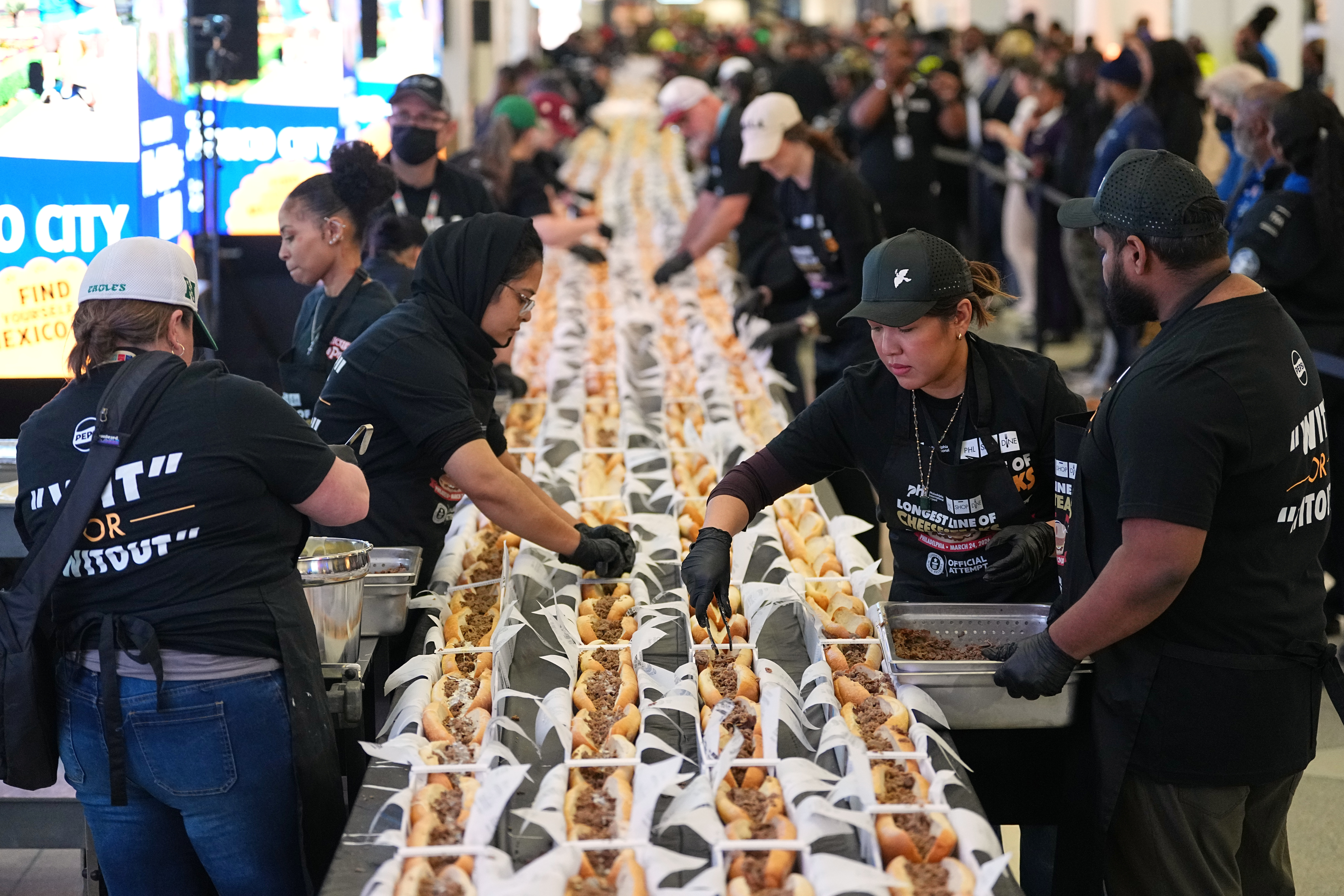 Volunteers assemble cheesesteaks in a Guinness World Record attempt on National Cheesesteak Day at Philadelphia International Airport, March 24, 2026, Philadelphia.
