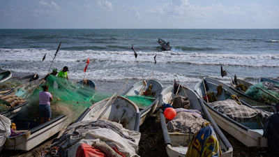 Fishermen untangle a net after suspending fishing trips because of an oil spill, Salinas, Mexico, March 26, 2026.