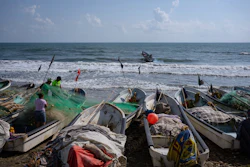 Fishermen untangle a net after suspending fishing trips because of an oil spill, Salinas, Mexico, March 26, 2026.