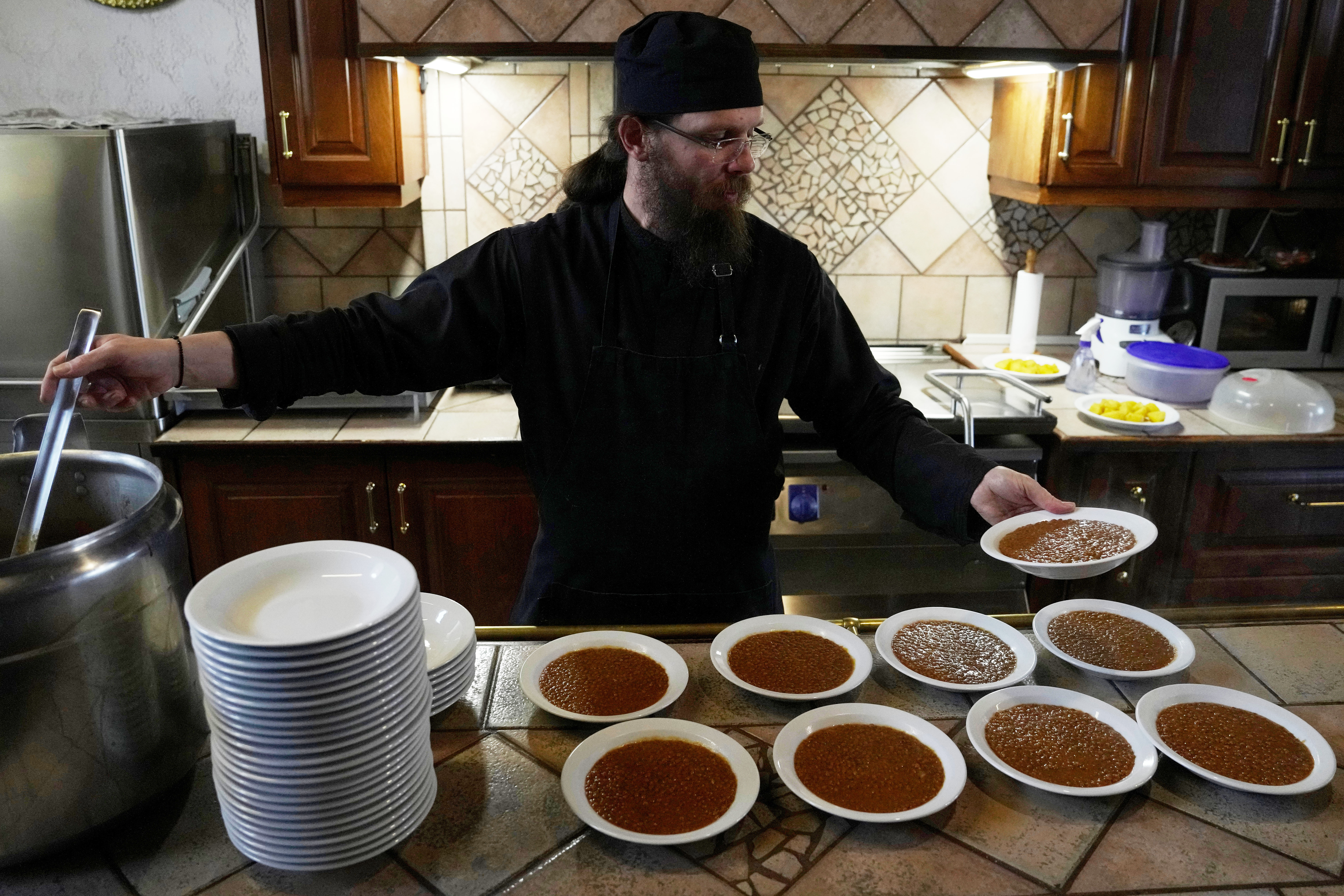Father Isaac serves lentils for the midday meal at the Monastery of St. Augustine and Seraphim of Sarov, Trikorfo, Greece, March 20, 2026.