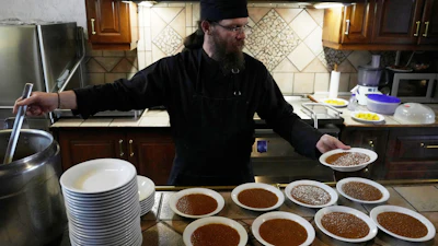 Father Isaac serves lentils for the midday meal at the Monastery of St. Augustine and Seraphim of Sarov, Trikorfo, Greece, March 20, 2026.
