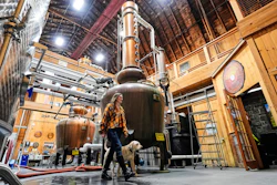 Meghan Ireland and her dog, Murphy, walk by one of the 750-gallon pot and column whiskey stills at the WhistlePig distillery Monday, April 6, 2026, in Shoreham, Vermont.
