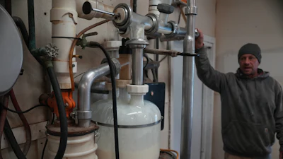 Herdsman Stephen Reed watches raw cow milk collect in a receive jar before it is eventually pasteurized at Ronnybrook Farm in Ancramdale, N.Y., on April 22, 2026.