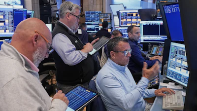 Robert Finnerty Jr., foreground right, works with colleagues on the floor of the New York Stock Exchange, May 7, 2026.