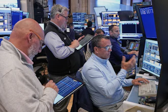 Robert Finnerty Jr., foreground right, works with colleagues on the floor of the New York Stock Exchange, May 7, 2026.