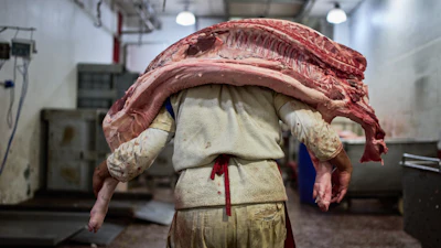 A worker carries pork inside a butcher shop at the Mataderos meat market in Buenos Aires, May 14, 2026.