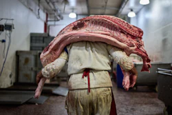 A worker carries pork inside a butcher shop at the Mataderos meat market in Buenos Aires, May 14, 2026.