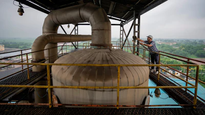 A technician works on the top deck of a distillery at Bajaj Hindustan Sugar factory that produces ethanol, Meerut, India, Aug. 23, 2023.