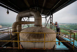 A technician works on the top deck of a distillery at Bajaj Hindustan Sugar factory that produces ethanol, Meerut, India, Aug. 23, 2023.