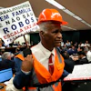 Lawmaker and Pastor Sargento Isidorio holds a sign supporting the end of Brazil's six-day workweek in the Chamber of Deputies, Brasilia, May 27, 2026.