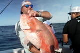Chris Kemp holds up a red snapper on the charter boat Jodie Lynn II before releasing it off St. Augustine, Fla., May 22, 2026.