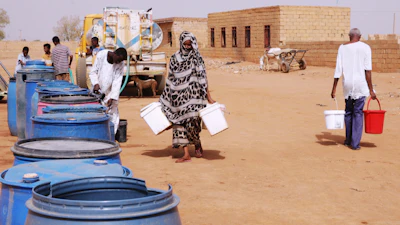 People fill water containers at a free distribution point amid water outages in Khartoum, Sudan, May 18, 2026.