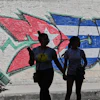 People walk past graffiti in the colors of the Cuban flag in Havana, June 17, 2026.