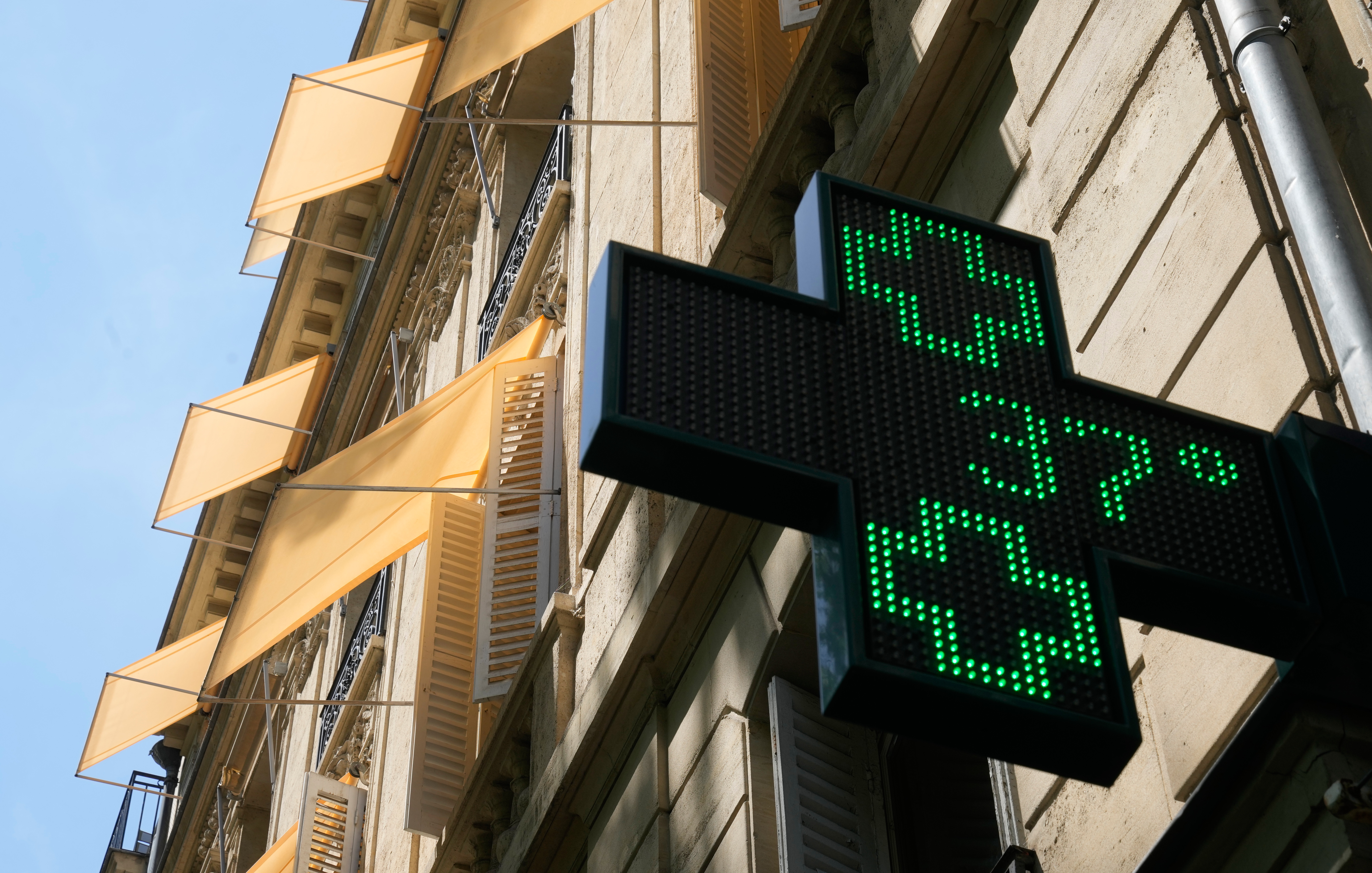 A sign outside a pharmacy displays a temperature of 37 degrees Celsius (98.6 degrees Fahrenheit) in Paris, June 21, 2026.