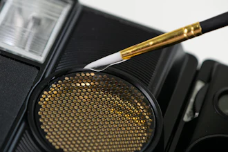 Gold makeup brush and eyeshadow palette with dotted texture on black cosmetic palette