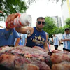 Lucas Martinez seasons meat with salt while grilling during a rally in Dallas, June 21, 2026.