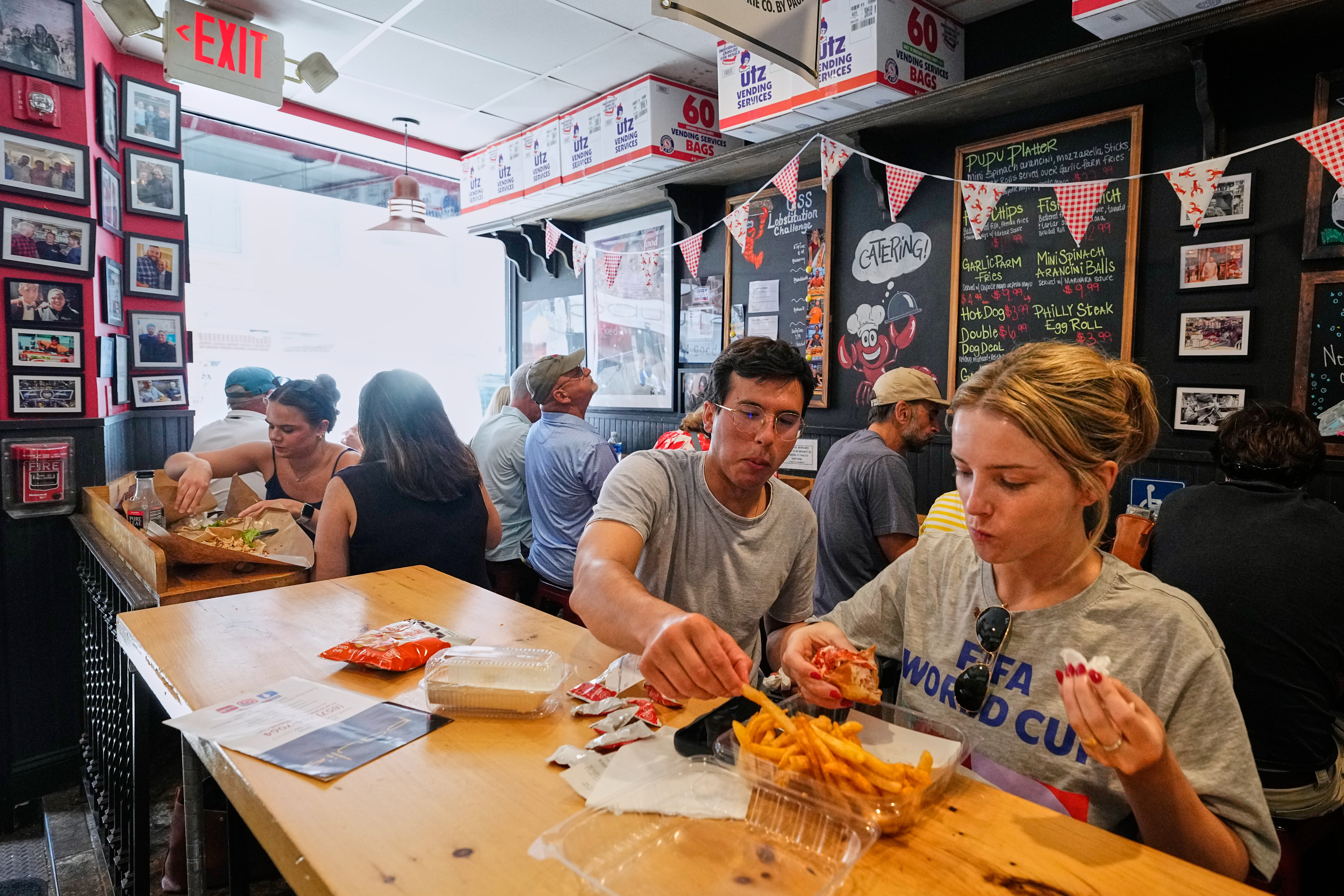 People wearing World Cup shirts taste sandwiches at Pauli's sandwich shop in the North End of Boston, June 24, 2026.