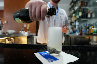 A bartender pours a glass of sparkling wine at the United Club lounge in Minneapolis, June 29, 2026.