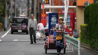 Akiko Sugaya blows a horn while she peddles tofu, prepared food and beverages in a cart in Tokyo, July 4, 2026.