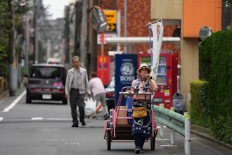 Akiko Sugaya blows a horn while she peddles tofu, prepared food and beverages in a cart in Tokyo, July 4, 2026.