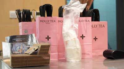 Bags with the Molly Tea brand and logo at a shop in Beijing, July 7, 2026.
