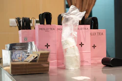Bags with the Molly Tea brand and logo at a shop in Beijing, July 7, 2026.