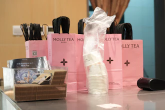 Bags with the Molly Tea brand and logo at a shop in Beijing, July 7, 2026.