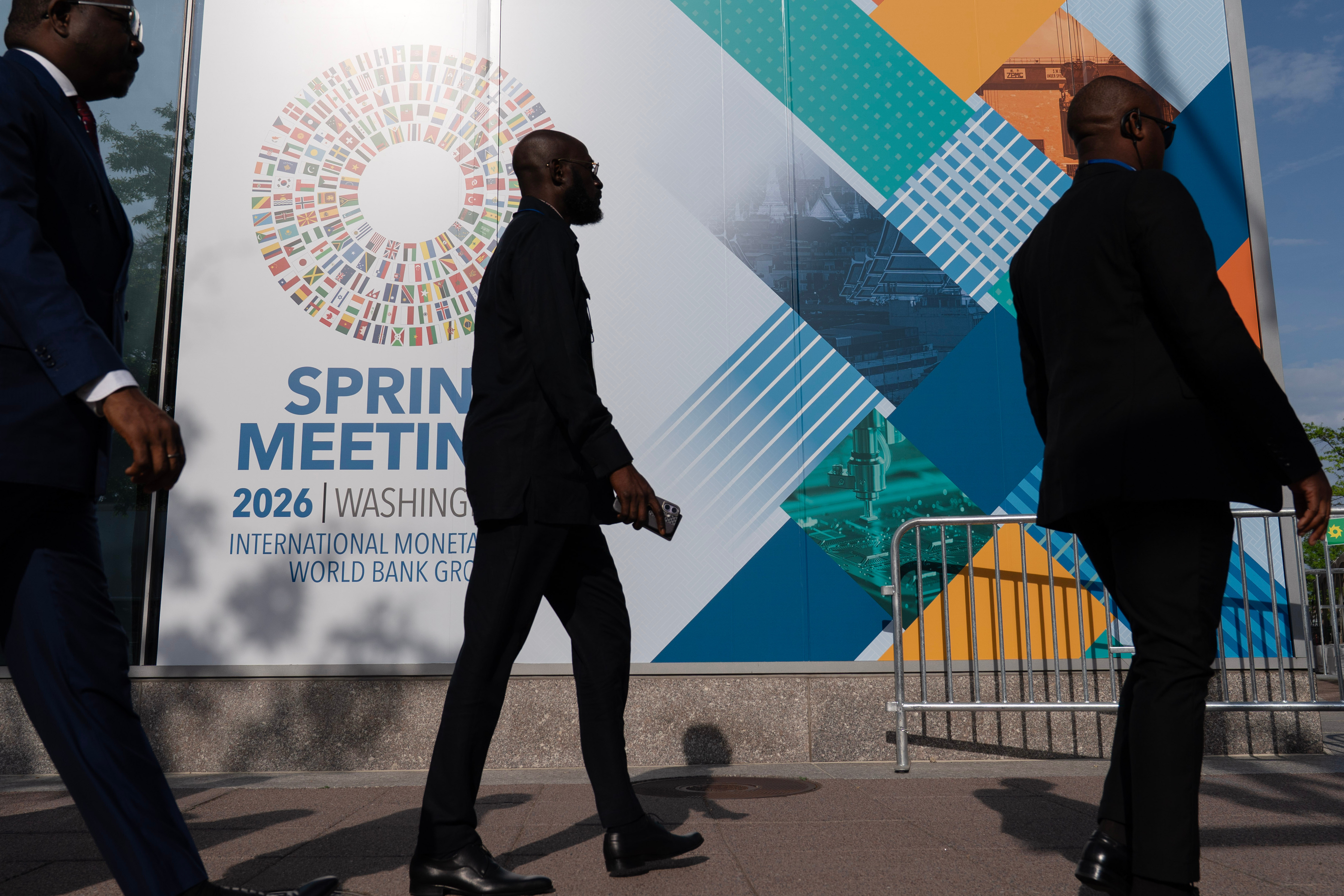 Delegates walk to the entrance of the International Monetary Fund headquarters during the World Bank/IMF Spring Meetings in Washington, April 15, 2026.