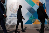 Delegates walk to the entrance of the International Monetary Fund headquarters during the World Bank/IMF Spring Meetings in Washington, April 15, 2026.