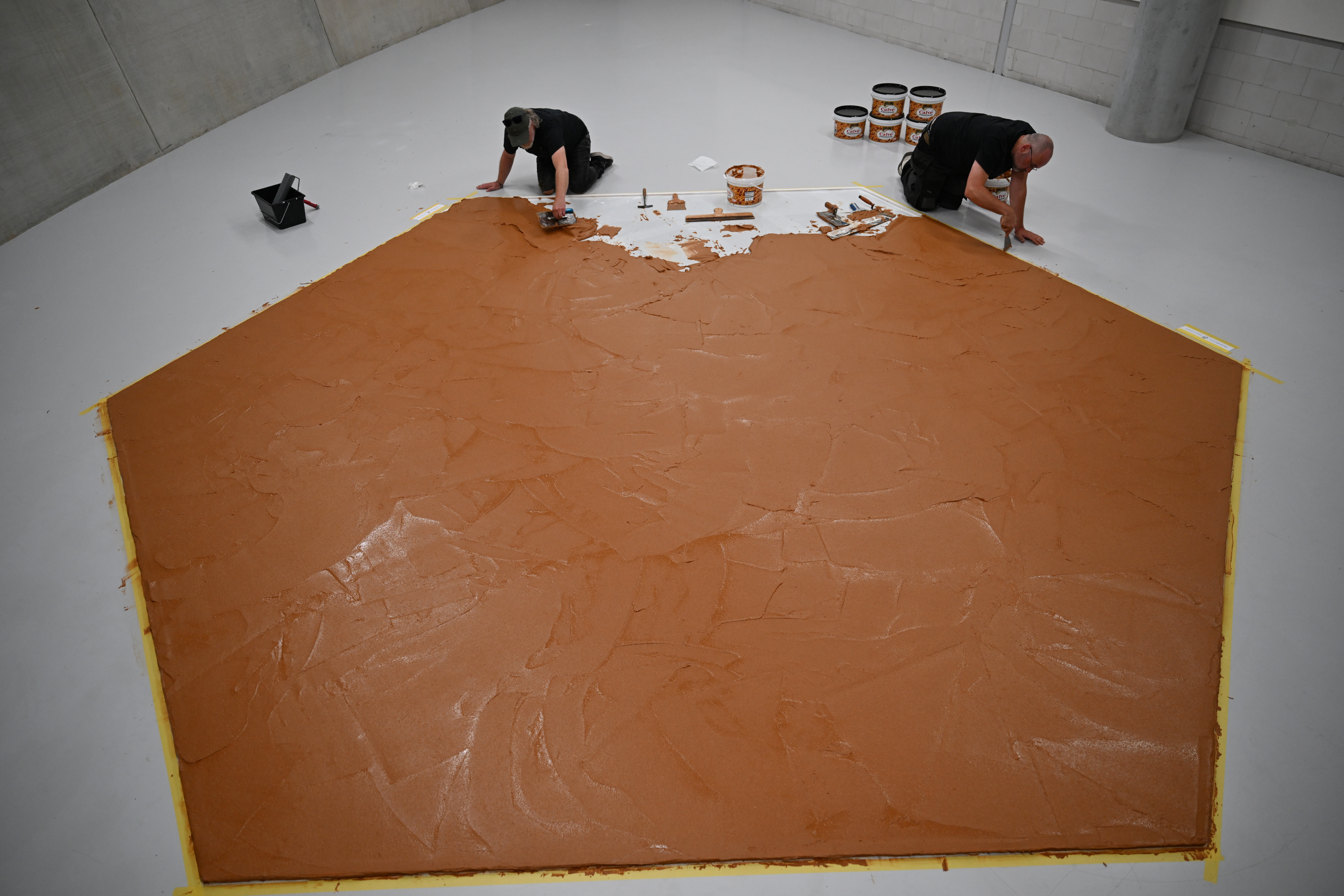 Workers spread peanut butter on a floor at the Museum Boijmans Van Beuningen, Rotterdam, Netherlands, July 3, 2026.