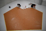 Workers spread peanut butter on a floor at the Museum Boijmans Van Beuningen, Rotterdam, Netherlands, July 3, 2026.