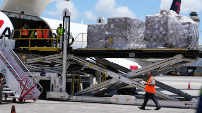 People load pallets containing food and hygiene kits for a humanitarian assistance flight to Cuba, July 21, 2026, Miami.