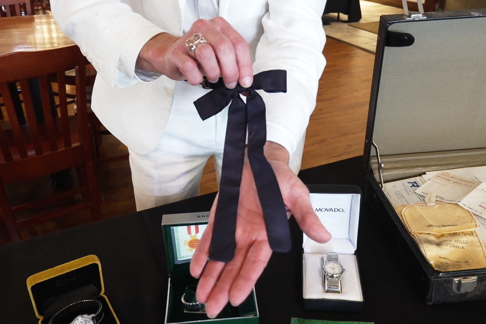 Auctioneer Jonathan Klunk shows a black bow tie worn by KFC founder Harland Sanders, Shelbyville, Ky., July 22, 2026.
