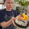 Noma's head of R&D Mette Brink Soberg holds a berry gazpacho dish topped with flower petals, Copenhagen, July 28, 2026.