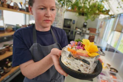 Noma's head of R&D Mette Brink Soberg holds a berry gazpacho dish topped with flower petals, Copenhagen, July 28, 2026.