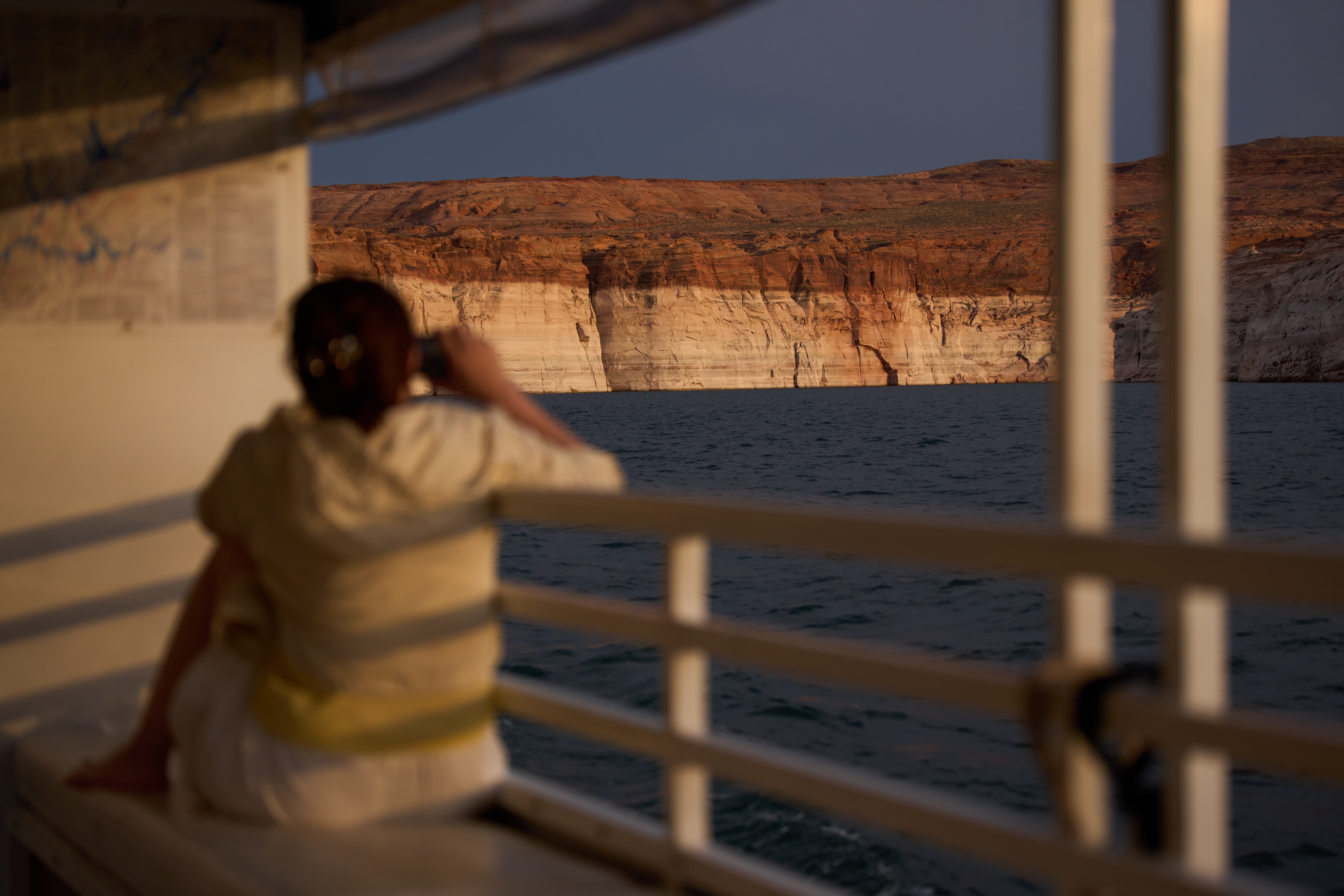 A person takes a picture during a tour on Lake Powell at the Glen Canyon National Recreation Area, July 15, 2026, near Page, Ariz.