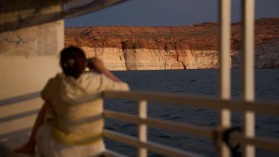 A person takes a picture during a tour on Lake Powell at the Glen Canyon National Recreation Area, July 15, 2026, near Page, Ariz.