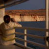 A person takes a picture during a tour on Lake Powell at the Glen Canyon National Recreation Area, July 15, 2026, near Page, Ariz.