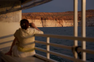 A person takes a picture during a tour on Lake Powell at the Glen Canyon National Recreation Area, July 15, 2026, near Page, Ariz.