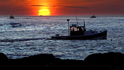 Lobster fishermen work at sunrise off Kennebunkport, Maine, Sept. 8, 2022.