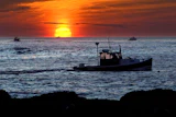 Lobster fishermen work at sunrise off Kennebunkport, Maine, Sept. 8, 2022.