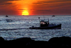 Lobster fishermen work at sunrise off Kennebunkport, Maine, Sept. 8, 2022.