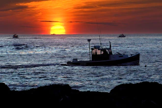 Lobster fishermen work at sunrise off Kennebunkport, Maine, Sept. 8, 2022.
